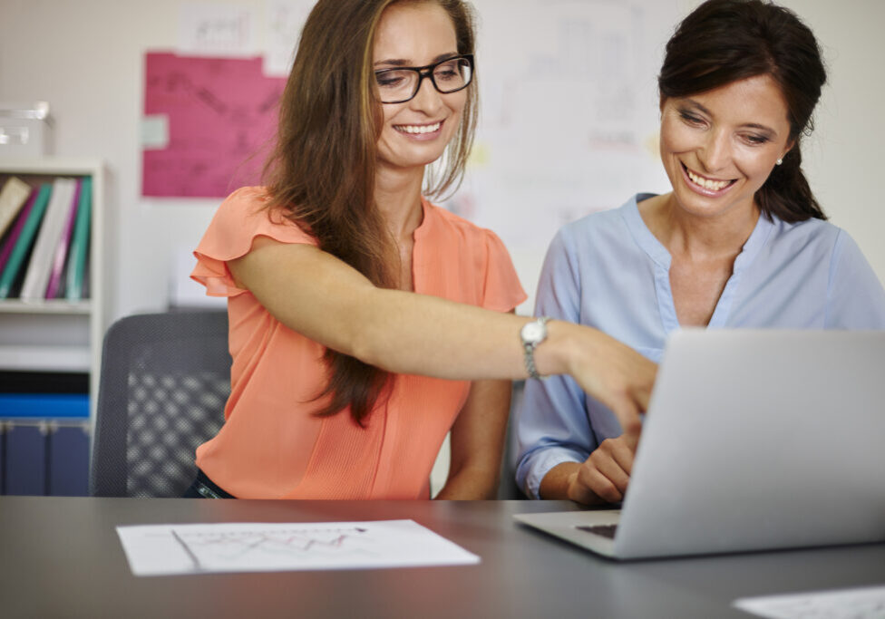 Two women working on computer in the office Two women working on computer in the office